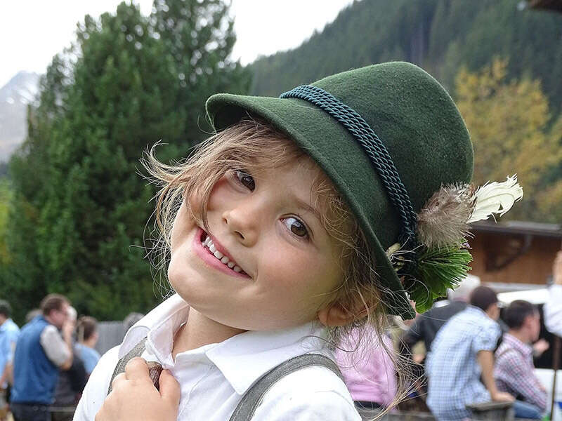 Kind mit Tirolerhut beim Almabtrieb vom Jenneweinhof