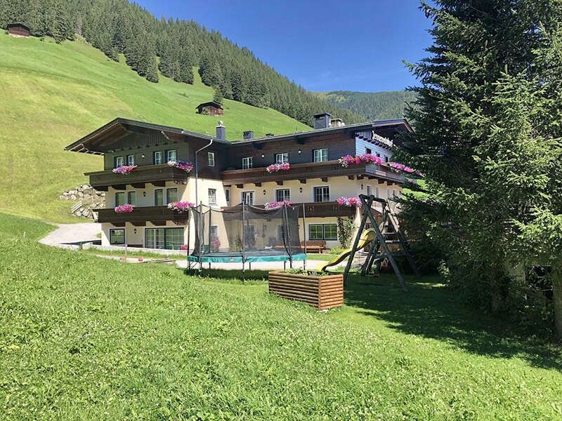 View of the house in summer with trampoline and playground