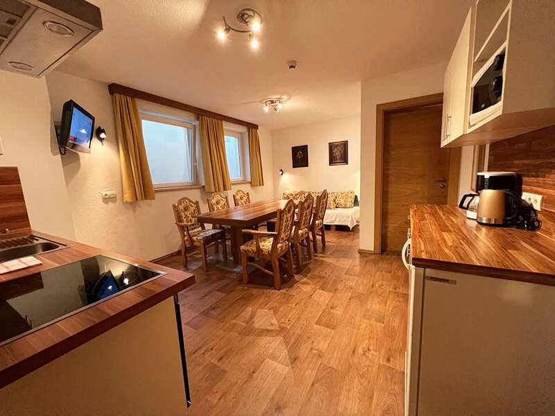 Guest kitchen with dining area and couch in the Jenneweinhof