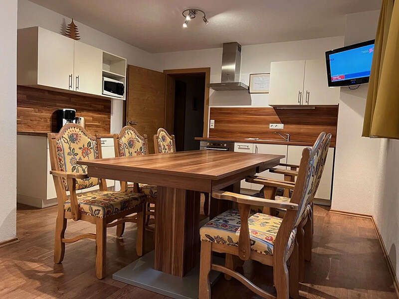 Guest kitchen with dining table and TV